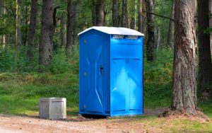 Porta potty outdoors under a tree